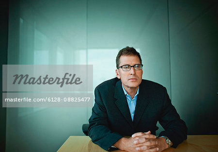 Businessman sitting at a table in an office building.