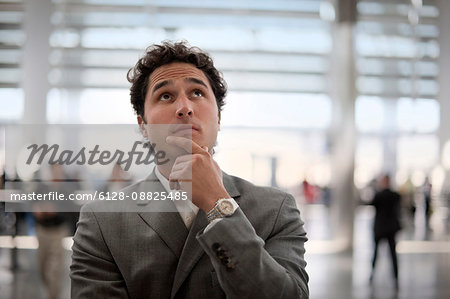 Businessman checking times on an airport information sign.