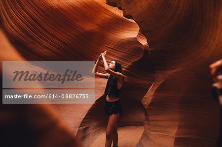 Woman taking photograph in cave, Antelope Canyon, Page, Arizona, USA