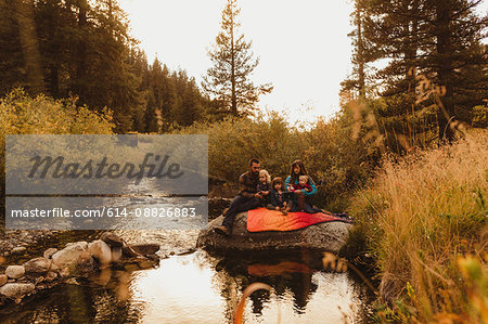 Family sitting on rock beside creek, fishing, Mineral King, Sequoia National Park, California, USA