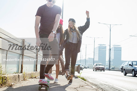 Skateboarders walking and skateboarding together on street, Budapest, Hungary