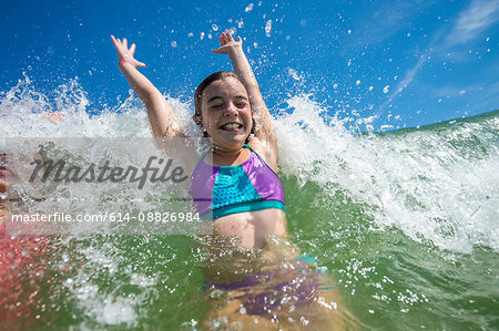 Girls jumping with joy in ocean wave