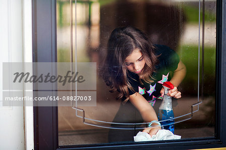 Girl bending down to clean glass door