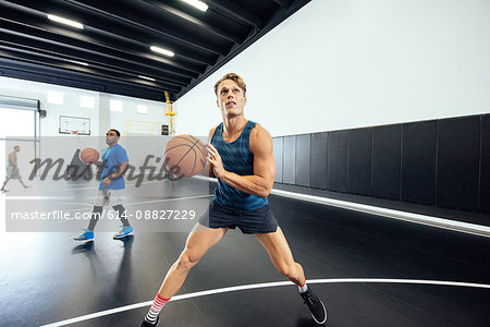 Male basketball player practicing aim on court