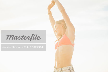 Woman with arms raised looking away