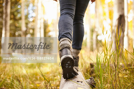 Woman walking on log, low section, Flagstaff, Arizona, USA