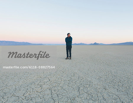 Man standing in vast desert playa at dawn, Black Rock Desert, Nevada