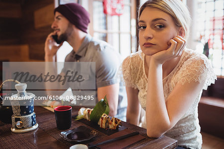 Man ignoring woman while talking on phone