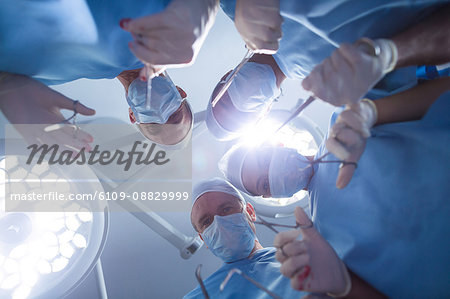 Group of surgeons performing operation in operation room