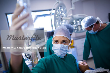 Female surgeons adjusting iv drip in operation theater