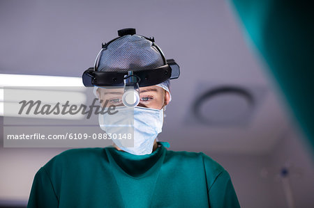 Female surgeon wearing surgical loupes while performing operation