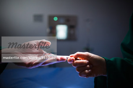 Surgeon passing scissors to colleague in operation theater