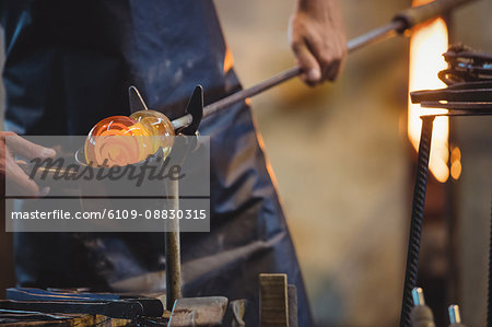 Glassblower forming and shaping a molten glass