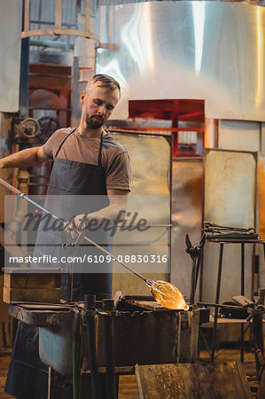 Glassblower shaping a molten glass