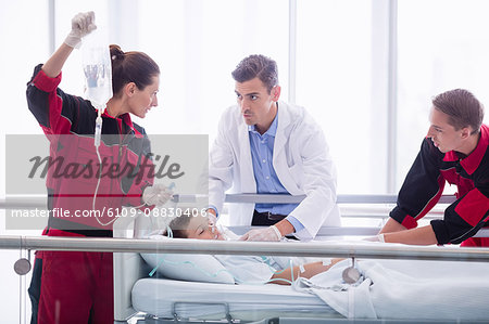 Doctors examining patient in corridor