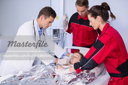 Doctor and paramedic examining a patient in emergency room