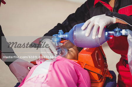 Paramedic giving oxygen to injured girl