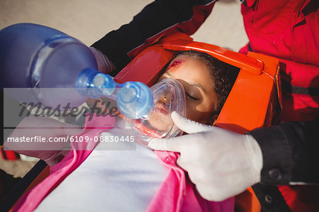 Paramedic giving oxygen to injured girl