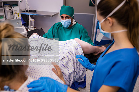 Medical team examining pregnant woman during delivery