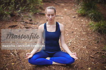 Woman performing yoga in forest