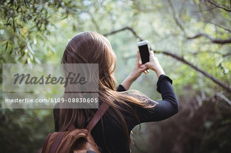 Rear view of woman taking selfie on mobile phone