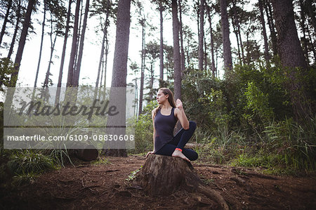 Woman performing yoga in forest