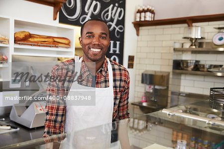 Business owner behind the counter at a sandwich bar