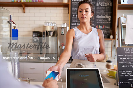 Waitress at coffee shop taking card payment from a customer