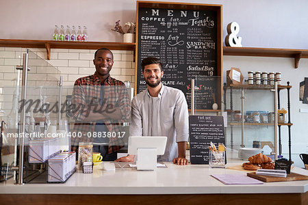 Business partners stand behind the counter at a coffee shop