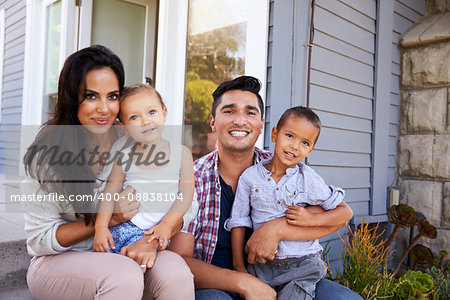 Portrait Of Family Sitting On Steps Outside Home