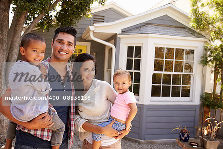 Portrait Of Family Standing Outside Home