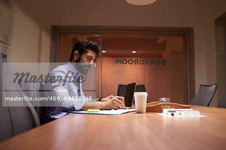 Middle aged Hispanic businessman working late in an office