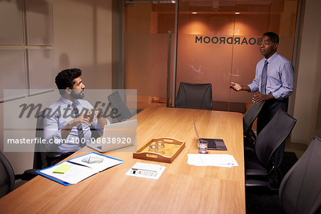 Businessman talks to colleague late in office, elevated view