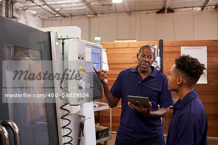 Engineer Training Young Male Apprentice On CNC Machine