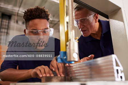 Carpenter Training Male Apprentice To Use Mechanized Saw