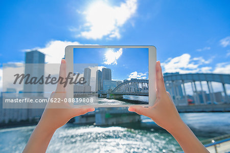 Japanese woman using augumented reality app on tablet downtown Tokyo, Japan
