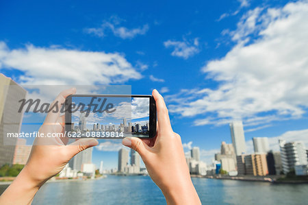 Japanese woman using augumented reality app on smartphone downtown Tokyo, Japan