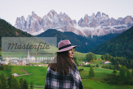 Woman looking over shoulder, Santa Maddalena, Dolomite Alps, Val di Funes (Funes Valley), South Tyrol, Italy