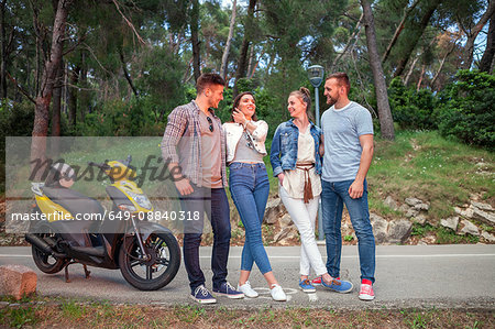 Two couples with moped chatting on rural road, Split, Dalmatia, Croatia