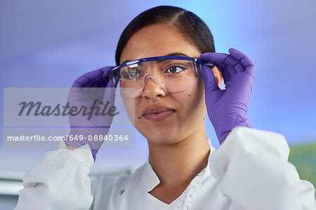 Scientist putting on safety glasses Scientist putting on safety glasses