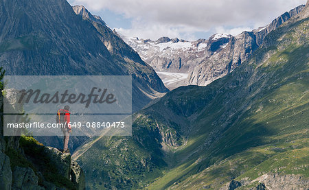 Lone male climber looking out from ridge,  Aletsch Glacier, Canton Wallis, Switzerland