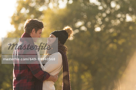 Young couple in rural setting, face to face, smiling