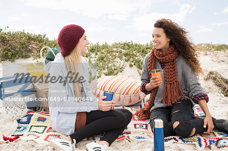 Two young women chatting beach picnic, Western Cape, South Africa