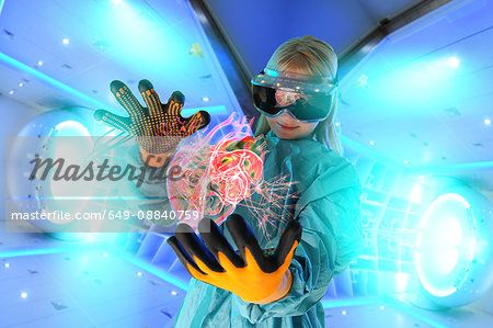Girl in virtual reality headset interacting with digital floating human heart Girl in virtual reality headset interacting with digital floating human heart