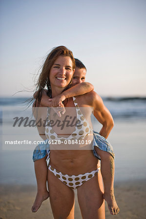 Mother giving her son a piggyback ride