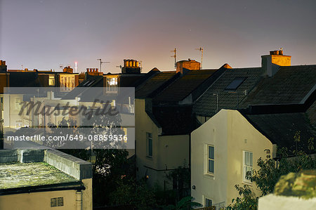 Elevated view of a row of terraced house roof tops at night, Brighton, East Sussex, England
