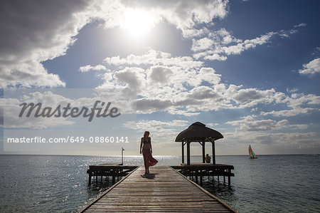 Woman walking along pier, Flic-en-Flac, Mauritius