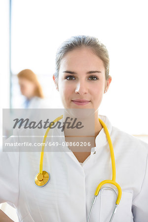 Portrait of young female doctor with yellow stethoscope