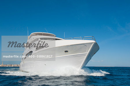 A large private motor yacht under way sailing out on tropical sea