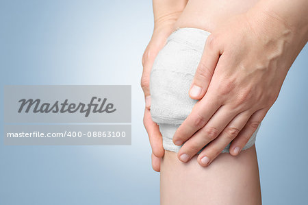 Injured painful knee with white gauze bandage